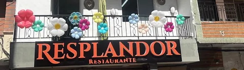 Franja del balcón de Resplandor Restaurante decorado con flores infladas de colores sobre el letrero RESPLANDOR RESTAURANTE.